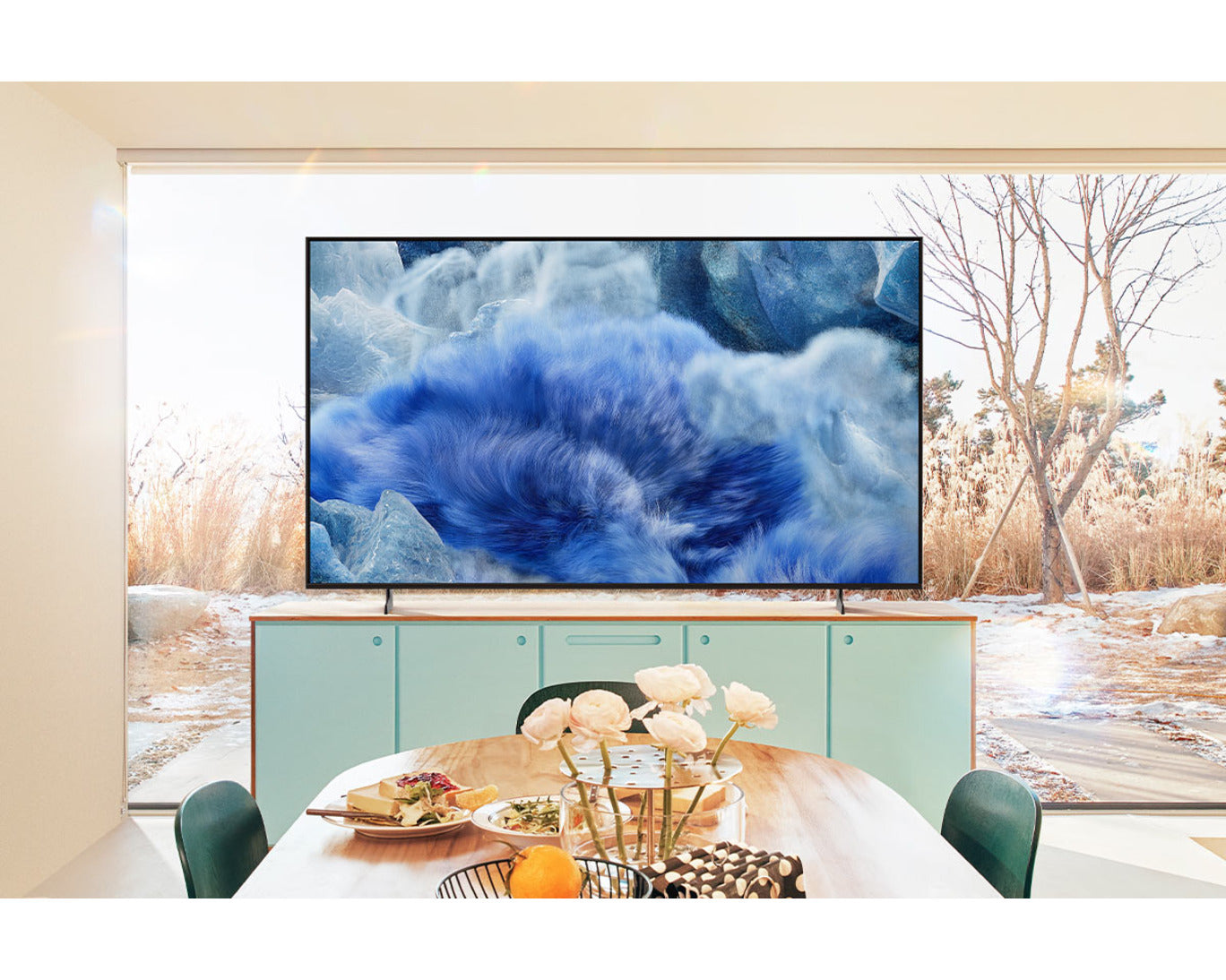 TV mounted on a wall with a scenic display, dining table in front