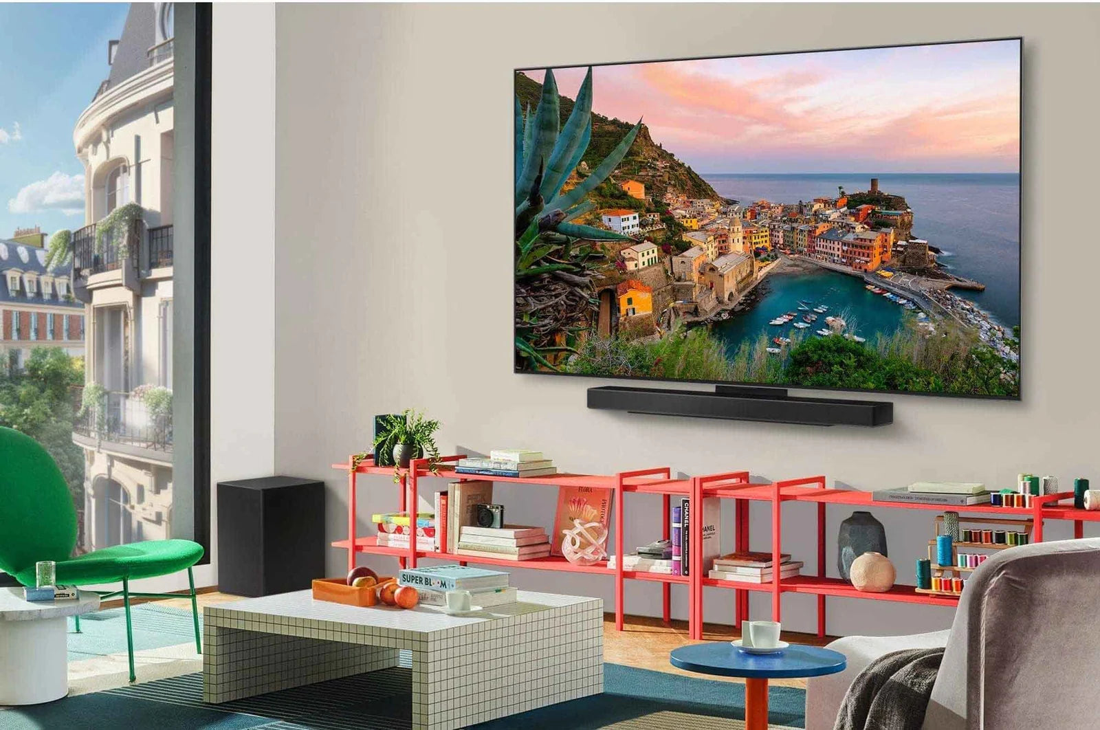 Modern living room with a large TV displaying a scenic view, surrounded by furniture and decor.
