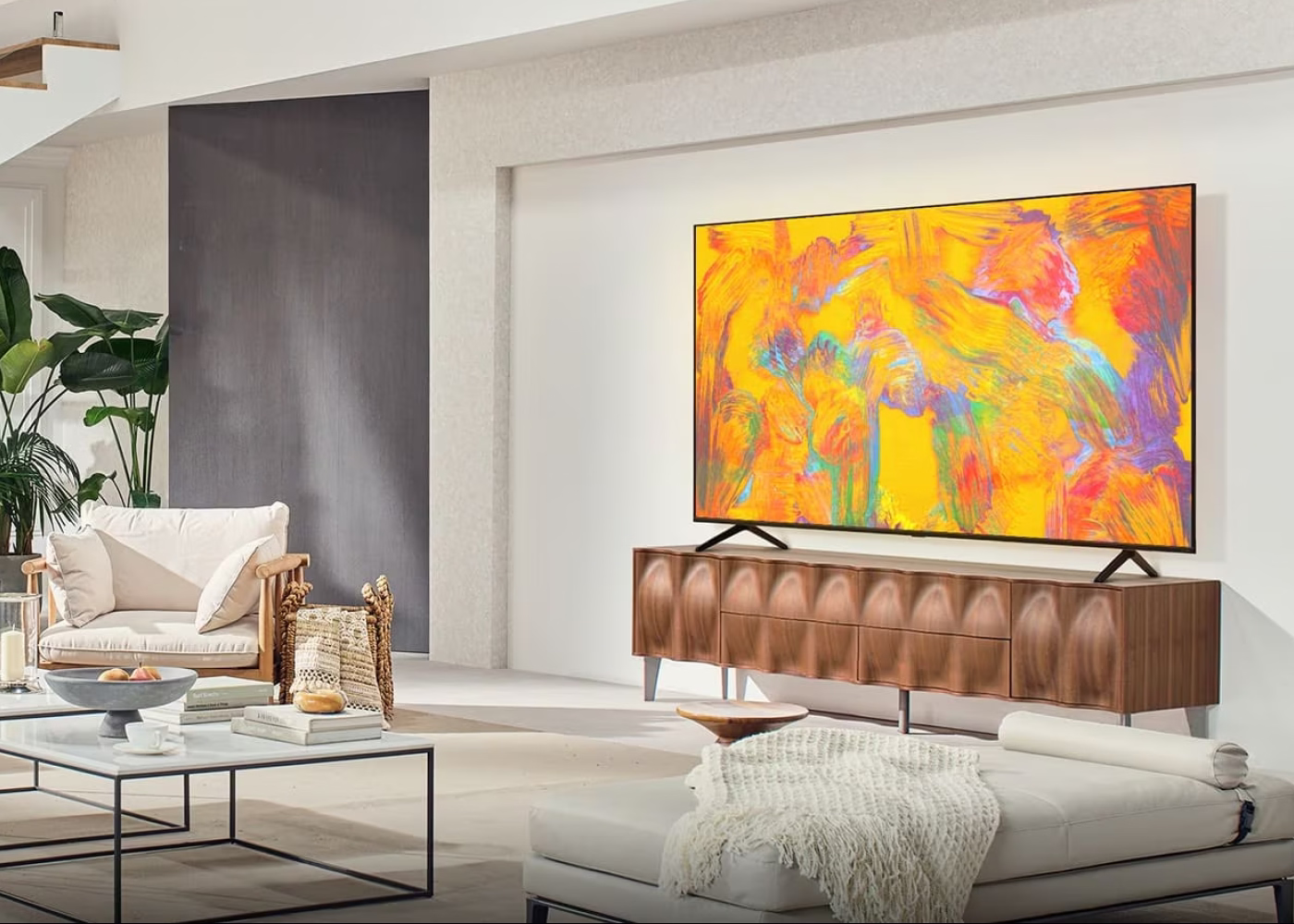 Modern living room with a large flat-screen TV displaying colorful abstract art.