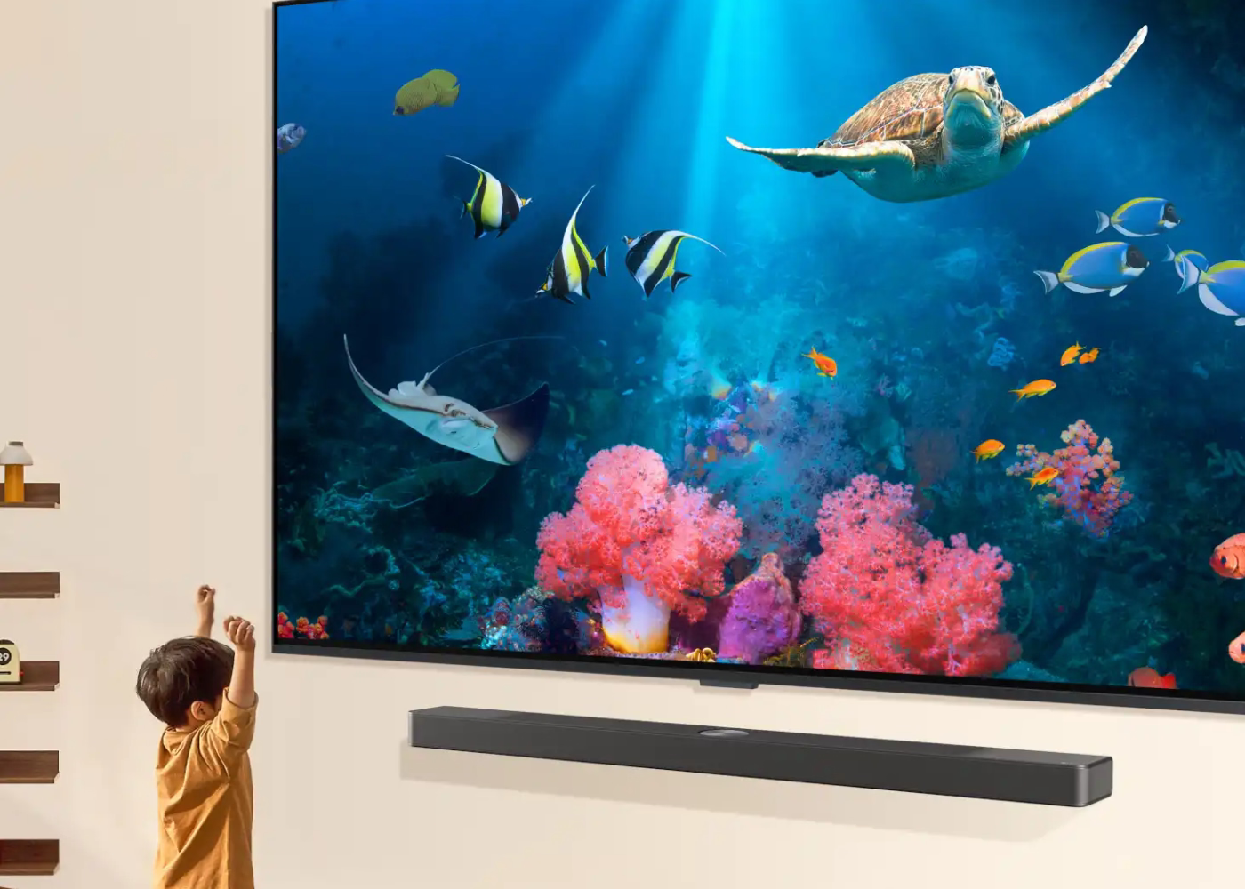 Child watching an underwater scene with fish and a turtle on a large TV screen.