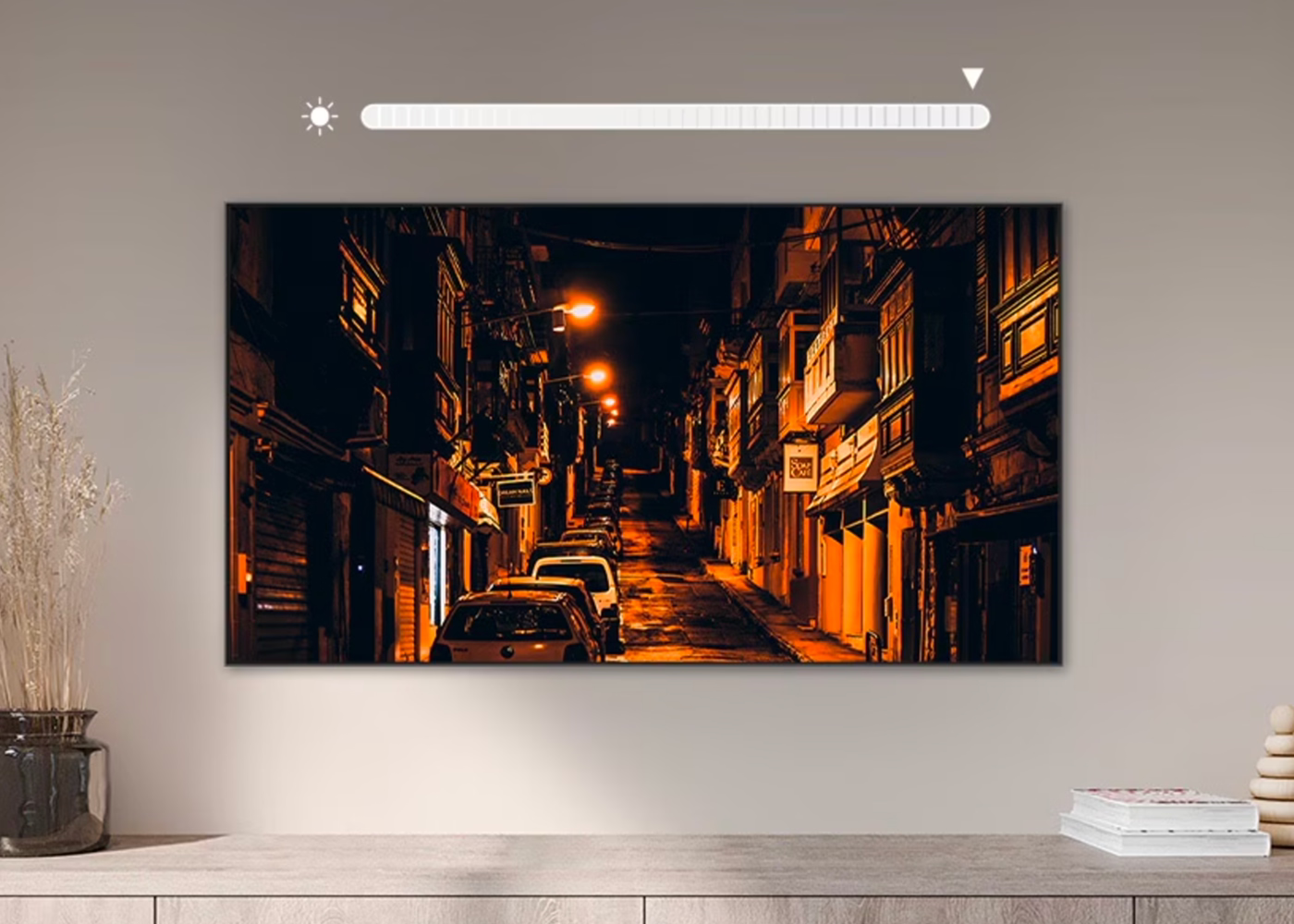 TV displaying a city street at night with cars on a wooden stand against a beige wall.