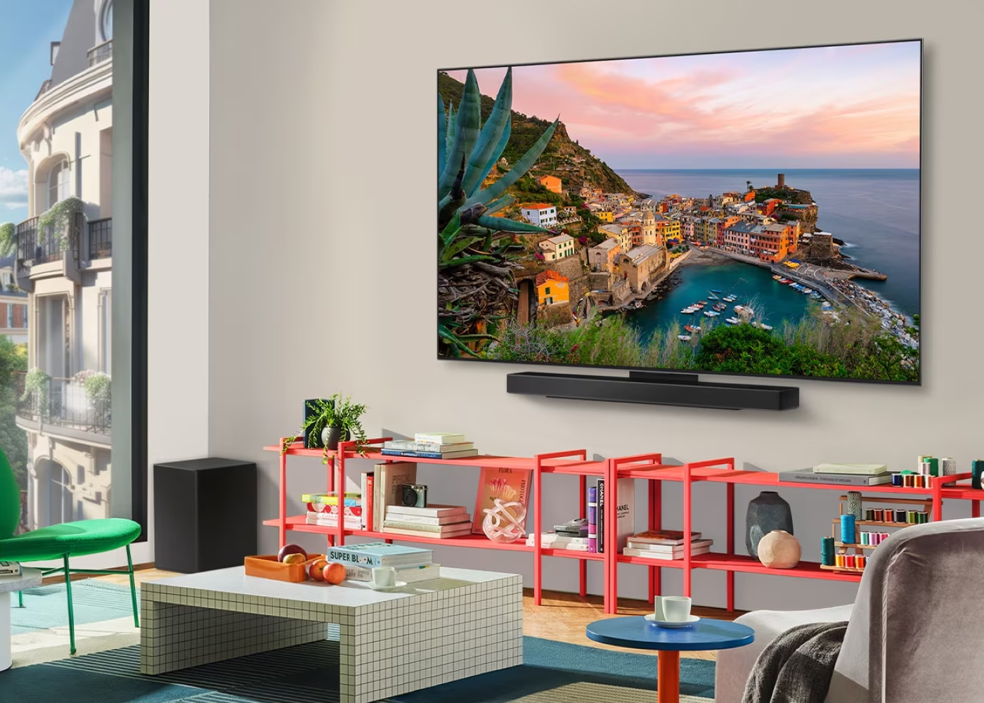 Modern living room with a large TV displaying a scenic view, red shelves, and a desk.