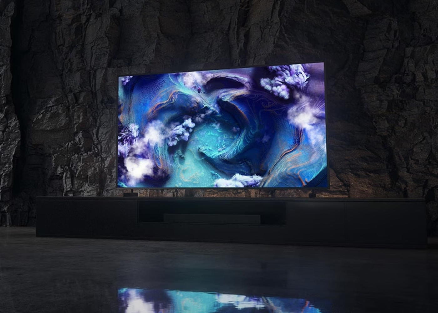 TV displaying a swirling abstract design in a dark room with stone walls.
