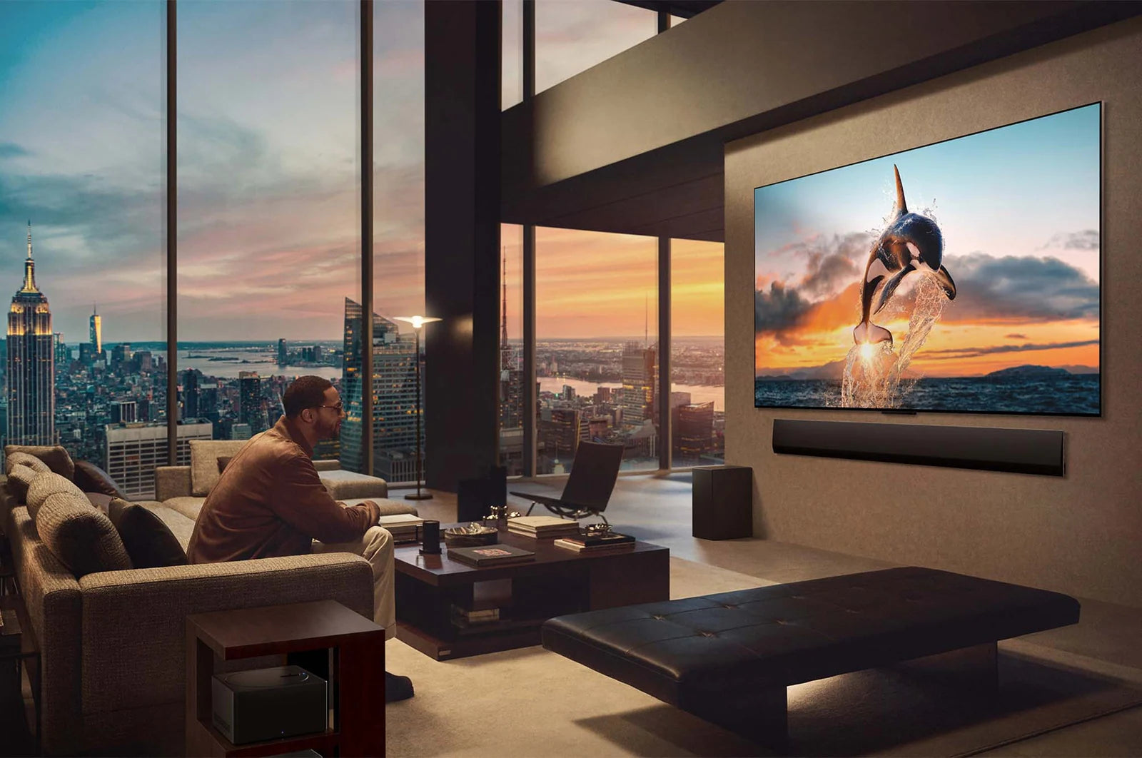 Modern living room with a large TV displaying a sunset scene, overlooking a city skyline.